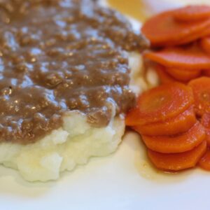 hamburger gravy with candied carrots on side