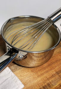 homemade cream of chicken soup in saucepan with whisk