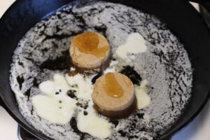 brown sugar, milk, and honey added to melted butter in cast iron pan