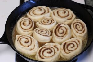 caramel rolls rising in cast iron pan