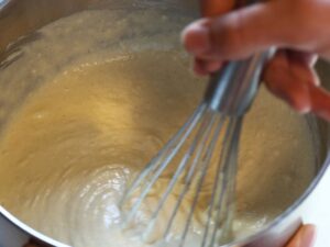 mixing dairy-free waffle batter in a bowl with whisk