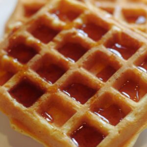 dairy-free waffles covered in maple syrup