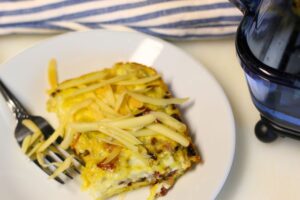 protein egg bake topped with cheese served on plate with fork alongside