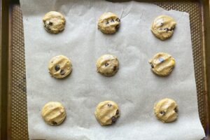 raw dairy free chocolate chip cookie dough flattened slightly on baking sheet