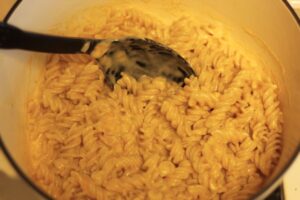 homemade gluten free macaroni and cheese in a Dutch oven with spoon