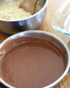 melted chocolate and peanut butter in saucepan. crisp rice cereal alongside.