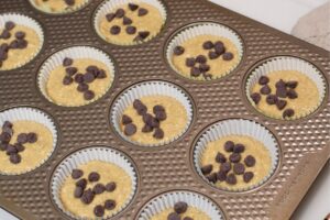 gluten free dairy free banana chocolate chip muffin batter in muffin tin sprinkled with chocolate chips