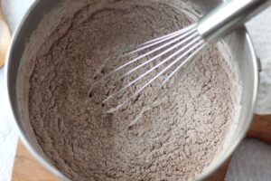 dairy free hot cocoa mix ingredients combined in mixing bowl with whisk