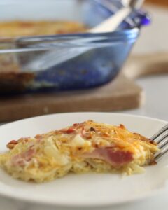 breakfast casserole with hashbrowns on a plate with a bite missing