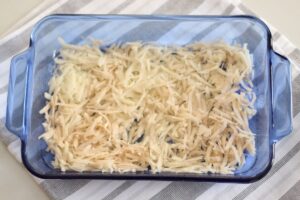 hashbrowns spread in bottom of glass casserole baking dish