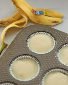mini banana cream pies in muffin tin next to banana peel