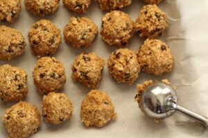 peanut butter energy balls on a parchment lined cookie sheet