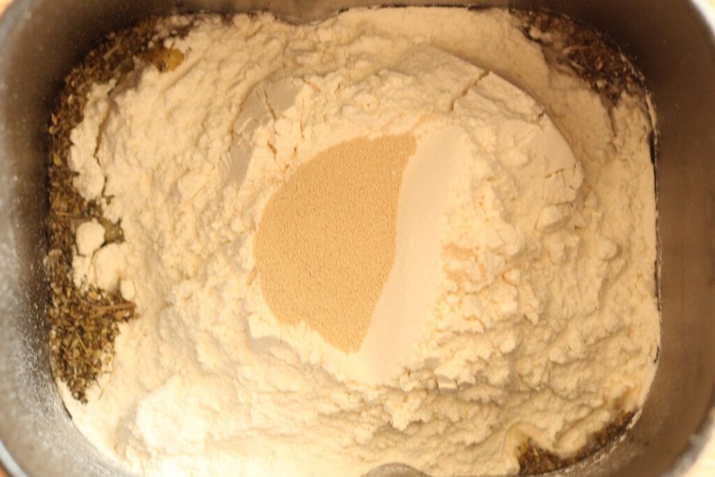 ingredients for bread machine Italian herb bread layered in bread maker pan