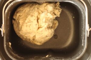 Italian herb bread dough ball in bread machine pan