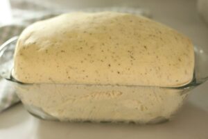 Italian herb bread risen in glass bread pan