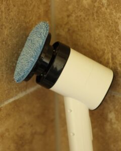 electric spin scrubber leaned up against shower wall