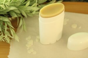 diy natural deodorant with beeswax pellets scattered around