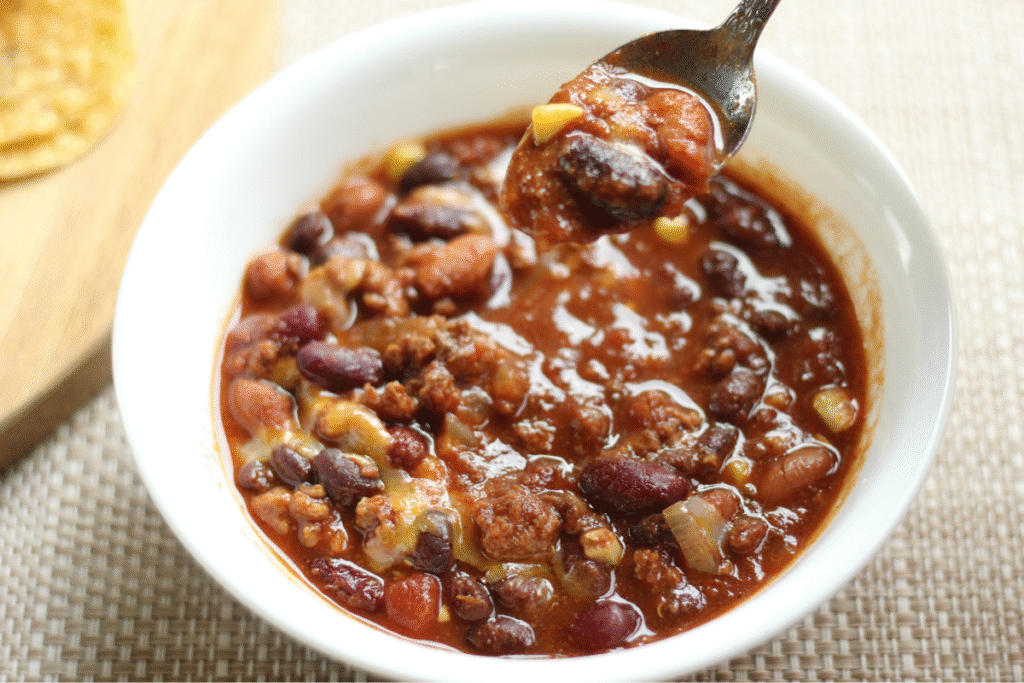 best homemade chili in a bowl with one scoop on a spoon