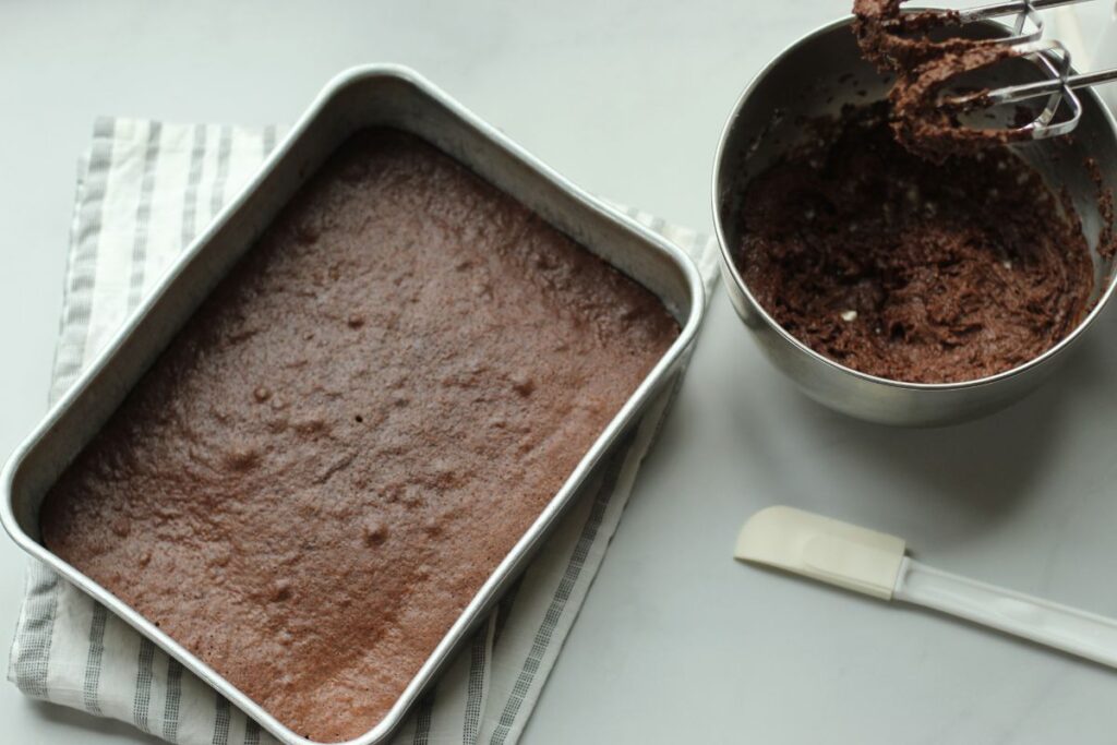 gluten free brownies in pan next to bowl of frosting