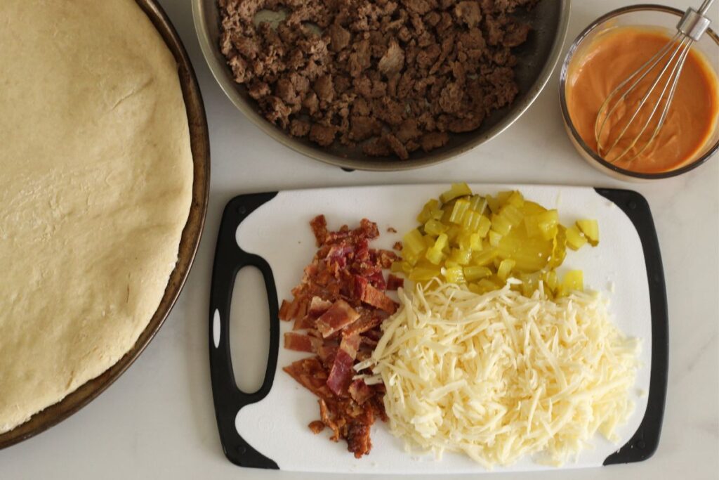 prepared ingredients for cheeseburger pizza