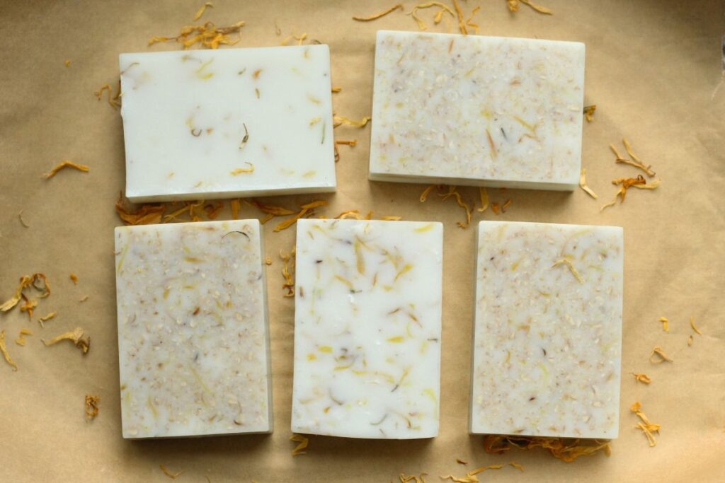 easy melt and pour soap bars laid out on parchment paper with calendula petals scattered around
