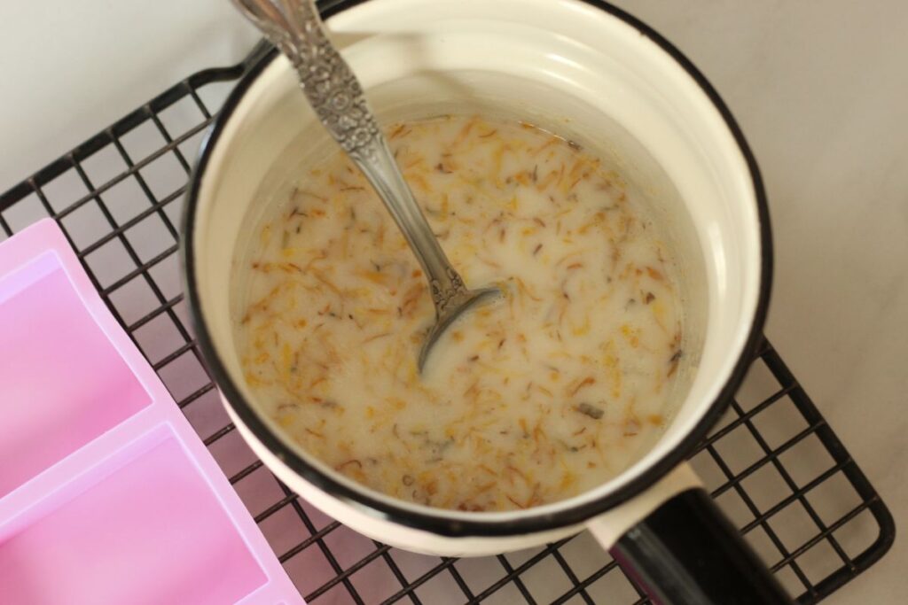 all ingredients for garden hands soap mixed together in double boiler with metal spoon.