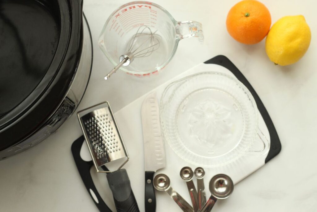 supplies needed for making citrus & herb crockpot chicken thighs on counter next to an orange & lemon